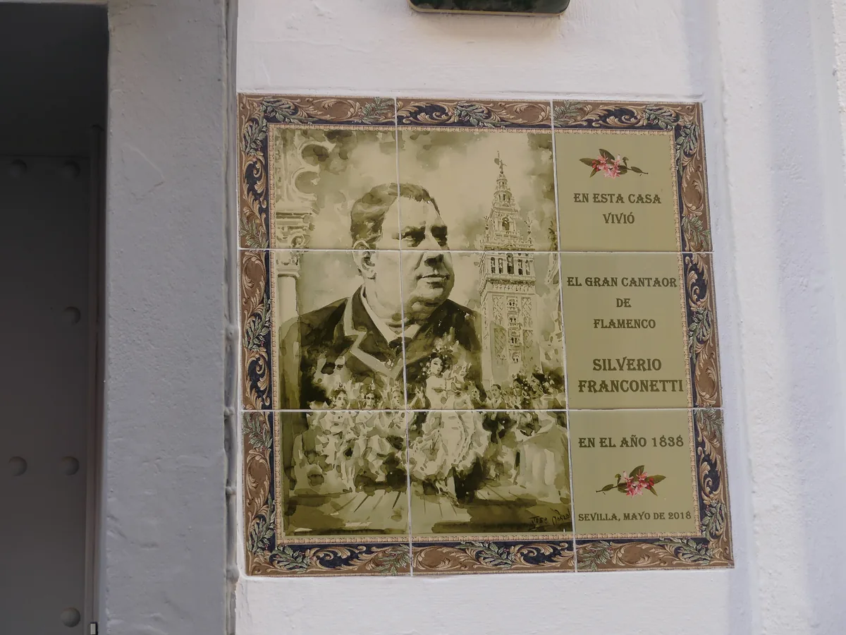 A ceramic tile plaque with a sepia portrait of a man beside the Giralda tower and a Spanish inscription about Silverio Franconetti